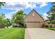Charming brick home with a well-manicured lawn, mature trees, and an attached two-car garage at 1850 Longest Dr, Franklin, IN 46131