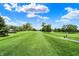 Scenic view of the golf course with lush green fairways and mature trees under a bright blue sky at 1850 Longest Dr, Franklin, IN 46131