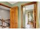 A well-lit hallway showcasing wood trim and multiple doorways leading to different areas of the house at 1850 Longest Dr, Franklin, IN 46131