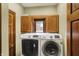 Laundry room with a white front-loading Samsung washer and dryer and wooden cabinets above at 1850 Longest Dr, Franklin, IN 46131