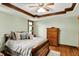 Bright main bedroom with a ceiling fan, hardwood floors, and soft green walls with lots of natural light at 1850 Longest Dr, Franklin, IN 46131