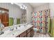 Bathroom featuring double sinks, a shower-tub combo, an a multi-colored shower curtain at 18514 Oriental Oak Ct, Noblesville, IN 46062