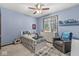 bedroom with blue walls, carpet floors, a ceiling fan, and a large window for natural light at 18514 Oriental Oak Ct, Noblesville, IN 46062