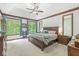 Spacious main bedroom featuring tray ceilings, a large window with green views, and ensuite bathroom access at 18514 Oriental Oak Ct, Noblesville, IN 46062