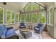 Cozy sunroom features vaulted ceilings, wooded views, and wicker furniture with blue cushions at 18514 Oriental Oak Ct, Noblesville, IN 46062