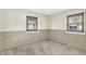 This is a bedroom with neutral walls, plush carpet, and natural light from two windows at 1868 N Hawthorne Ln, Indianapolis, IN 46218