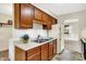 Traditional kitchen with wooden cabinets, double sink, white appliances, and vinyl flooring at 1868 N Hawthorne Ln, Indianapolis, IN 46218