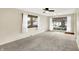 Bright living room featuring neutral walls, ceiling fan, and large windows providing natural light at 1868 N Hawthorne Ln, Indianapolis, IN 46218