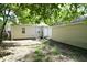 View of the backyard with a house and detached garage under the shade of trees at 1902 N Colorado Ave, Indianapolis, IN 46218