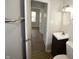 Bathroom with a white vanity, square sink, and a view into a room with natural light from a window at 1902 N Colorado Ave, Indianapolis, IN 46218