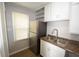 Compact kitchen featuring stainless steel appliances, modern flooring and white cabinets at 1902 N Colorado Ave, Indianapolis, IN 46218