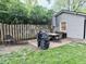 Backyard with shed and outdoor dining set on a brick patio with a grill at 1917 W Norwood Dr, Muncie, IN 47304