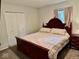 Cozy bedroom featuring a wood-framed bed, closet, and natural light from the window at 1917 W Norwood Dr, Muncie, IN 47304