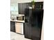 Close up of sink, counter, cabinets and appliances of kitchen with black cabinets at 1917 W Norwood Dr, Muncie, IN 47304