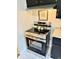 Close-up of stainless steel oven in kitchen with black cabinets and stone countertops at 1917 W Norwood Dr, Muncie, IN 47304