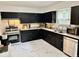 Spacious kitchen featuring black cabinets, modern appliances and marble-look flooring at 1917 W Norwood Dr, Muncie, IN 47304