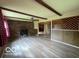 Open living room features vinyl flooring, beamed ceiling, and brick fireplace at 1998 Crescent St, Franklin, IN 46131