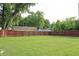 Large backyard with a vibrant green lawn and a tall wooden privacy fence at 202 S Church St, Brooklyn, IN 46111