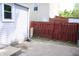View of a concrete backyard patio with a red fence and the home's exterior in the background at 202 S Church St, Brooklyn, IN 46111