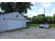 Detached garage with white door situated on a gravel drive with a well-maintained yard visible in the background at 202 S Church St, Brooklyn, IN 46111