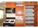 Kitchen featuring modern appliances, wooden cabinets, and a convenient pantry for storage at 202 S Church St, Brooklyn, IN 46111