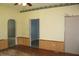 Living room featuring hardwood floors, wood paneled walls, ceiling fan and multiple doorways at 202 S Church St, Brooklyn, IN 46111