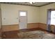 Living room featuring hardwood floors, wood paneled walls, a window, and a door to the exterior at 202 S Church St, Brooklyn, IN 46111