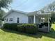Cozy one-story home featuring a covered porch, neat landscaping, and light blue siding at 2133 10Th St, Columbus, IN 47201