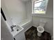 A clean bathroom with a bathtub, toilet, and a small sink under a window at 2310 E Raymond St, Indianapolis, IN 46203
