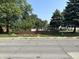 Charming exterior view, highlighted by mature trees, a cute fence, a mailbox with the property's address, and a shed at 2310 E Raymond St, Indianapolis, IN 46203