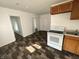 Bright kitchen featuring white appliances and wood cabinets with updated floors at 2310 E Raymond St, Indianapolis, IN 46203