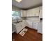 Modern kitchen with white cabinets, sleek countertops, stainless steel sink, and hardwood floors at , Beech Grove, IN 46107