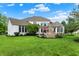 Backyard featuring a stone fireplace, patio set, lush green lawn and white house at 2535 Dawn Ridge Dr, Westfield, IN 46074