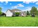 Expansive backyard featuring a white two-story home, large lawn, and stone fireplace at 2535 Dawn Ridge Dr, Westfield, IN 46074