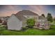 An exterior shot of a white home with a stone fireplace and lush green lawn at 2535 Dawn Ridge Dr, Westfield, IN 46074