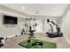 Basement workout area features weight machine, treadmill, wall mounted television, and putting green at 2535 Dawn Ridge Dr, Westfield, IN 46074