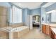 Bright bathroom with soaking tub, glass block window, double sinks and wood cabinets at 2535 Dawn Ridge Dr, Westfield, IN 46074