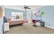 Bedroom with light blue walls and carpeted floors features bed, desk, shelving, and ceiling fan at 2535 Dawn Ridge Dr, Westfield, IN 46074