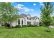 Charming white brick home with a well-manicured lawn, lush trees, and beautifully landscaped front yard at 2535 Dawn Ridge Dr, Westfield, IN 46074