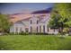 Two-story white brick home at sunset with lush lawn, manicured landscaping, and beautiful curb appeal at 2535 Dawn Ridge Dr, Westfield, IN 46074