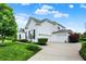 Side view of a white brick home showcasing a well-maintained yard and a spacious three-car garage at 2535 Dawn Ridge Dr, Westfield, IN 46074