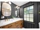 Modern bathroom featuring a double vanity, dark walls, stylish mirrors, and contemporary fixtures at 2715 Northview Ave, Indianapolis, IN 46220