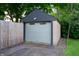 Detached garage with a gray door and siding, surrounded by trees and greenery at 2715 Northview Ave, Indianapolis, IN 46220
