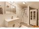 Bright bathroom with white vanity, stylish mirror, cabinet, and decorative shower curtain at 28 N Elizabeth St, Indianapolis, IN 46219
