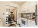 Kitchen with white appliances and cabinetry open to the dining room featuring black and white checkered floors at 28 N Elizabeth St, Indianapolis, IN 46219