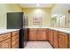 A kitchen-like wet bar area with wood cabinets and a black refrigerator provides convenience and style at 3295 Allison Ct, Carmel, IN 46033