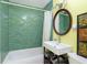 Bathroom featuring green tile surround, white vanity, and decorative accents at 3338 Orchard Ave, Indianapolis, IN 46218