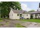 Quaint yellow home featuring a well-maintained lawn and paved driveway, offering comfort and curb appeal at 3338 Orchard Ave, Indianapolis, IN 46218