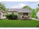 Charming single-story home with a cozy front porch, green lawn, and mature landscaping at 3338 Orchard Ave, Indianapolis, IN 46218