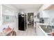 Galley kitchen featuring white cabinets, stainless steel appliances, and tile flooring at 3338 Orchard Ave, Indianapolis, IN 46218